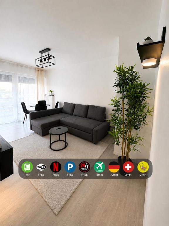 a living room with a couch and a table at LorOtel - Frontiere - Aeroport in Saint-Louis