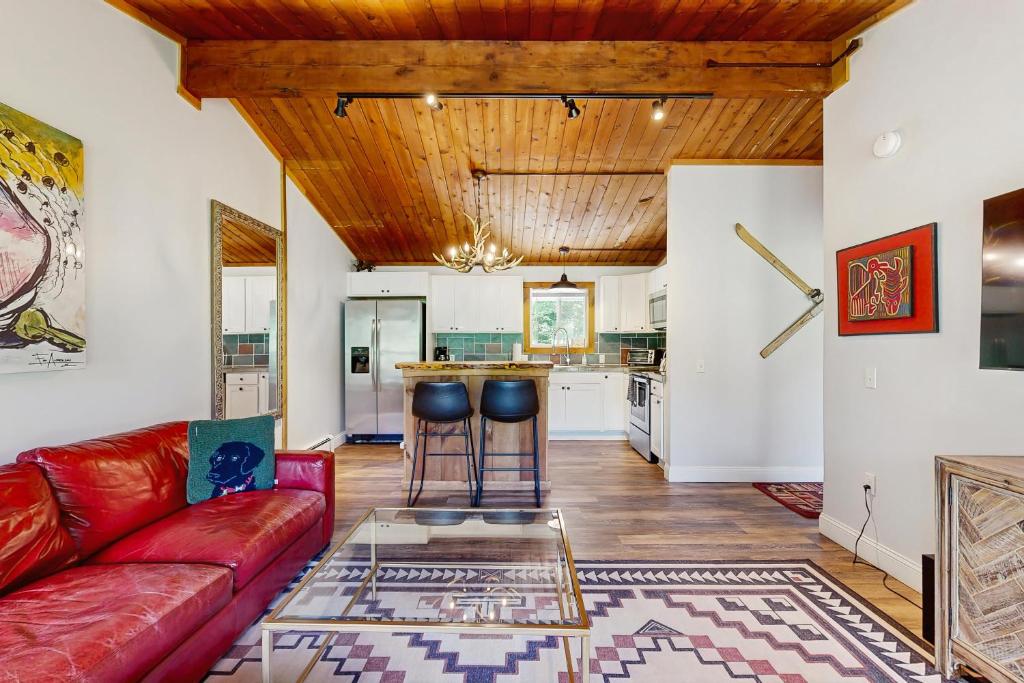 a living room with a red couch and a table at Griffin Chalet 5 in Stowe