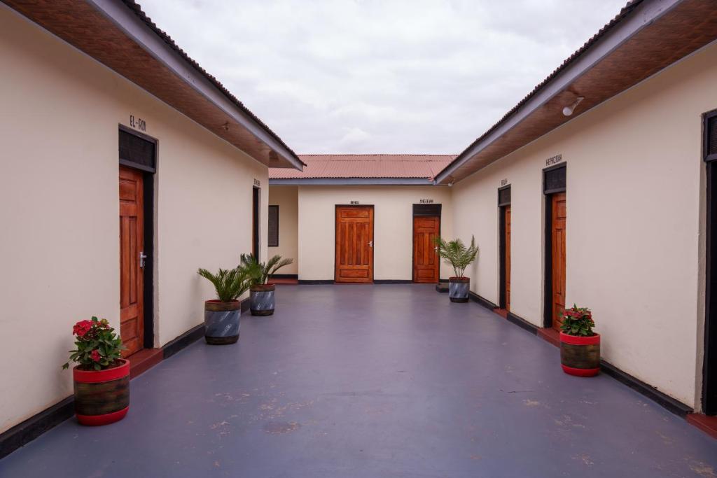 a corridor of a building with doors and potted plants at Elikai Hostels 