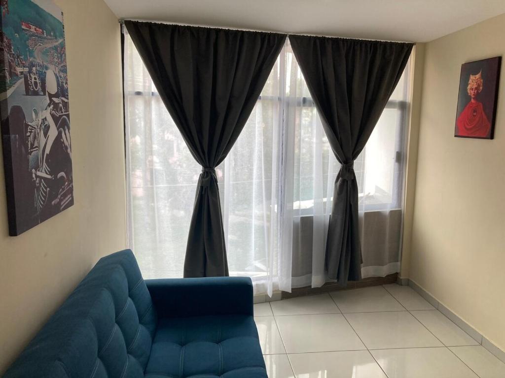a living room with a blue couch in front of a window at Beautiful, comfortable and functional apartment 4 in Guadalupe