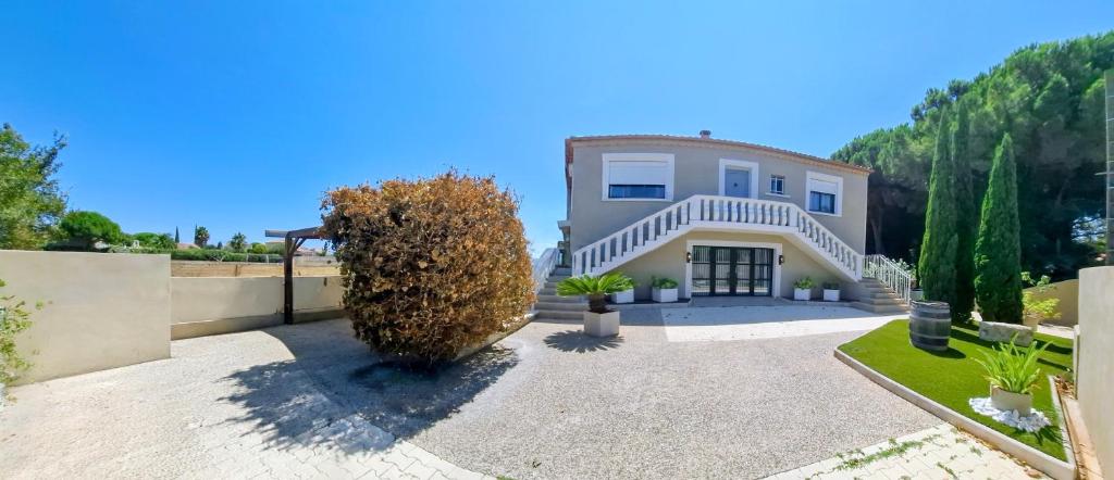 a house with a large bush in front of it at La Villa Francoismarie in Bouzigues
