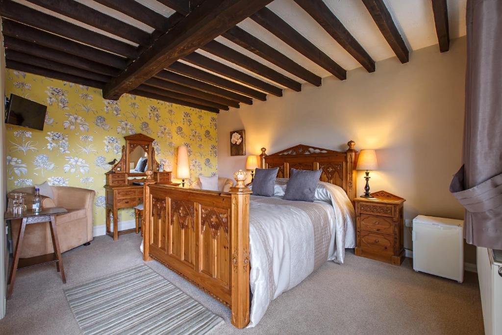 a bedroom with a wooden bed and a desk at The Barns in Cromer