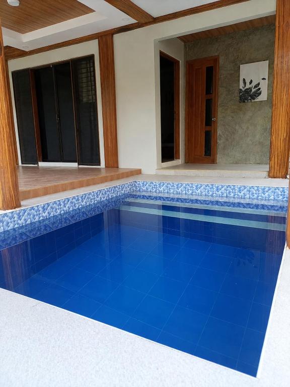 a swimming pool with blue tile in a house at Villa de Miguel in Migit