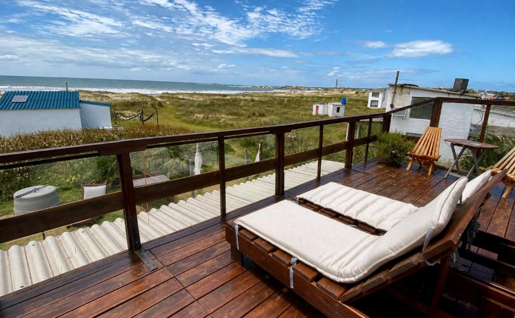 a balcony with a hammock and a view of the beach at Carmela Suites Cabo Polonio in Cabo Polonio