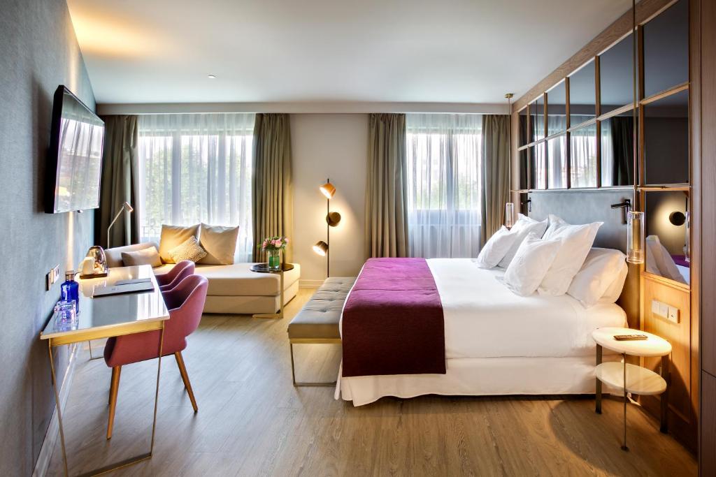 a hotel room with a large bed and a couch at Barceló Emperatriz in Madrid