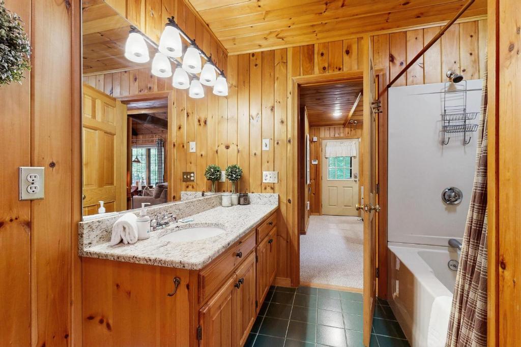 a bathroom with a sink and a tub and a refrigerator at Four Seasons at the Lake in Bridgton