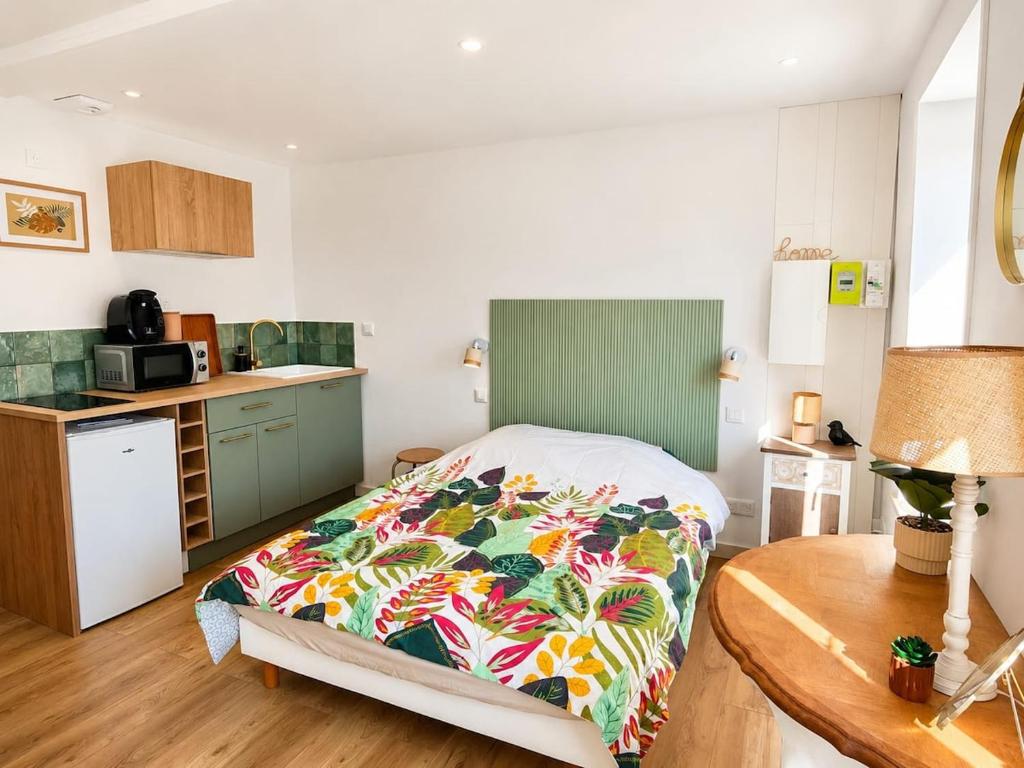 a small bedroom with a bed and a kitchen at L'oasis, studio hyper centre in Desvres
