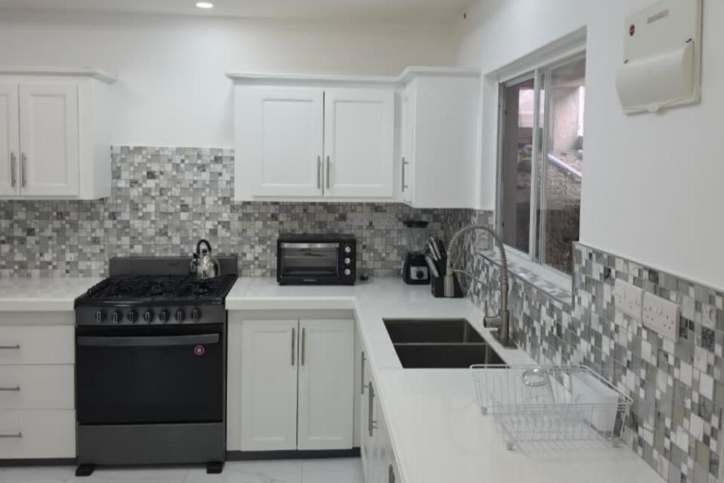 a kitchen with white cabinets and a black stove at Tranquil Haven in Bellevue