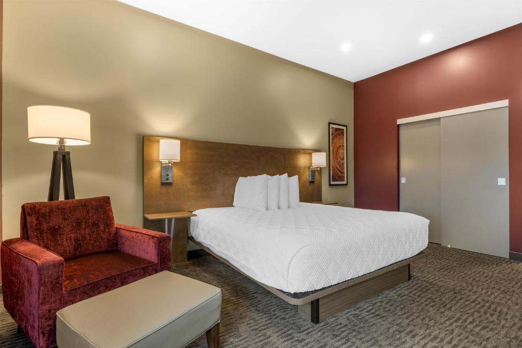 a hotel room with a bed and a chair at Best Western Plus Dauphin in Dauphin