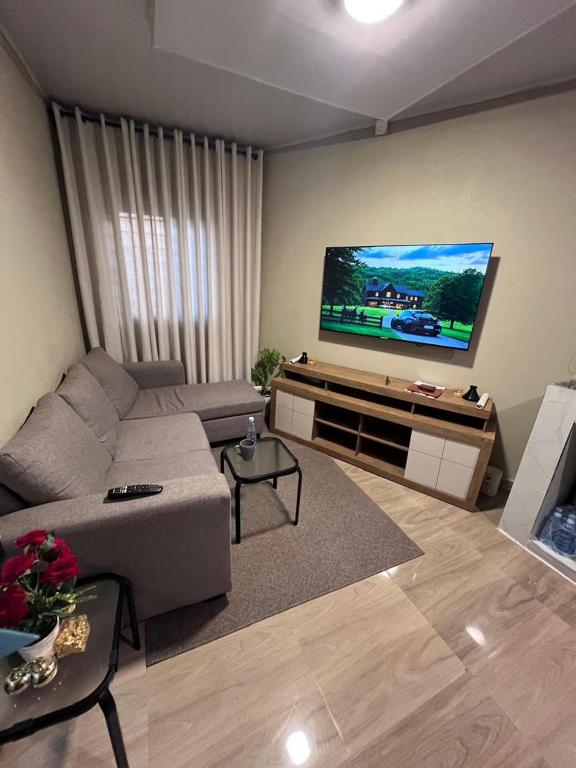 a living room with a couch and a flat screen tv at Lynch Apartments 2 - Mimosa Chilanga in Lusaka