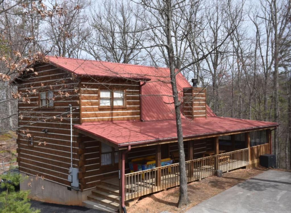 a cabin in the woods with a red roof at Sugar Bear in Sevierville