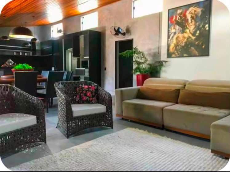 a living room with a couch and chairs and a table at A Oca Praiana Suites in Ilha Comprida