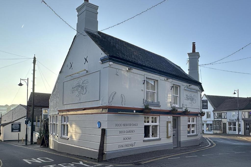 a white building on the side of a street at Lobster Sheringham in Sheringham
