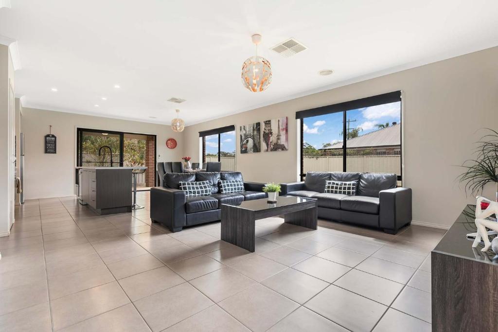 a living room with couches and a table at 28 Skye Ave - Skye High on Style in Moama