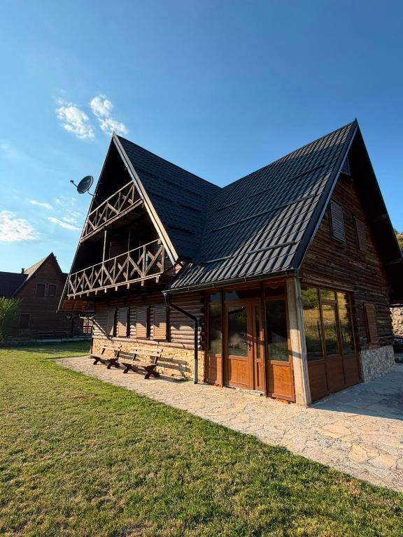 a large wooden building with a black roof at Winter Dream Vlašić in Šišava