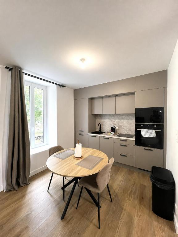 a kitchen with a table and chairs in a room at LOCAPONDI 5 - Les Reflets du Canal in Pontivy