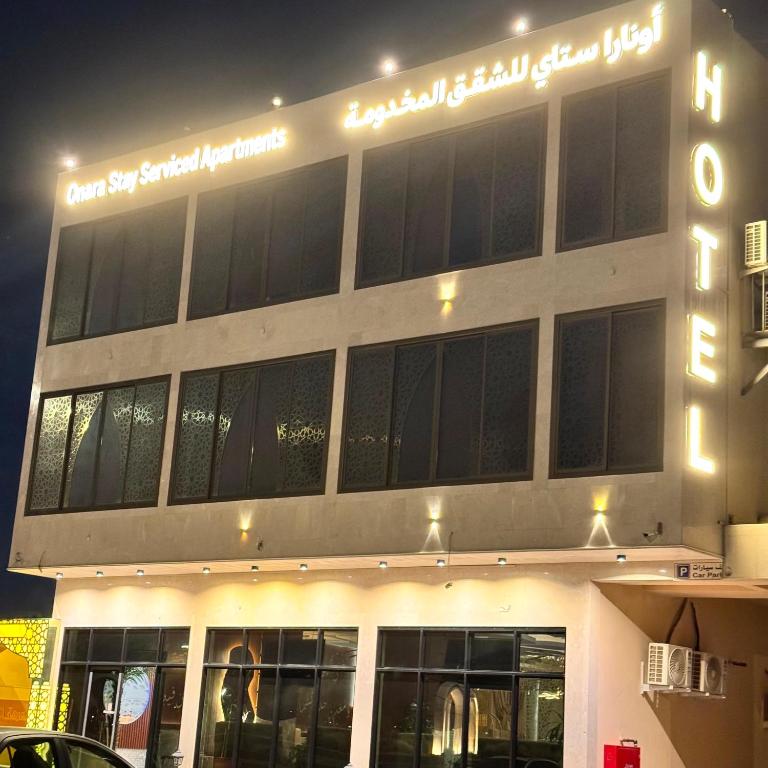 a building with a sign on the side of it at أونارا ستاي 3 للشقق المخدومة in Sīdī Ḩamzah