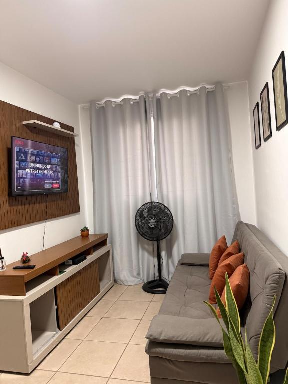 a living room with a couch and a television at Spazio Cristalli Comfort in Cuiabá