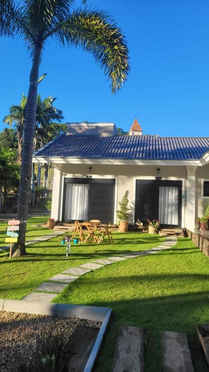 a house with a palm tree in the yard at Villa Pomerode Hospedagem - Suítes com conforto e aconchego conectados com a Natureza in Pomerode