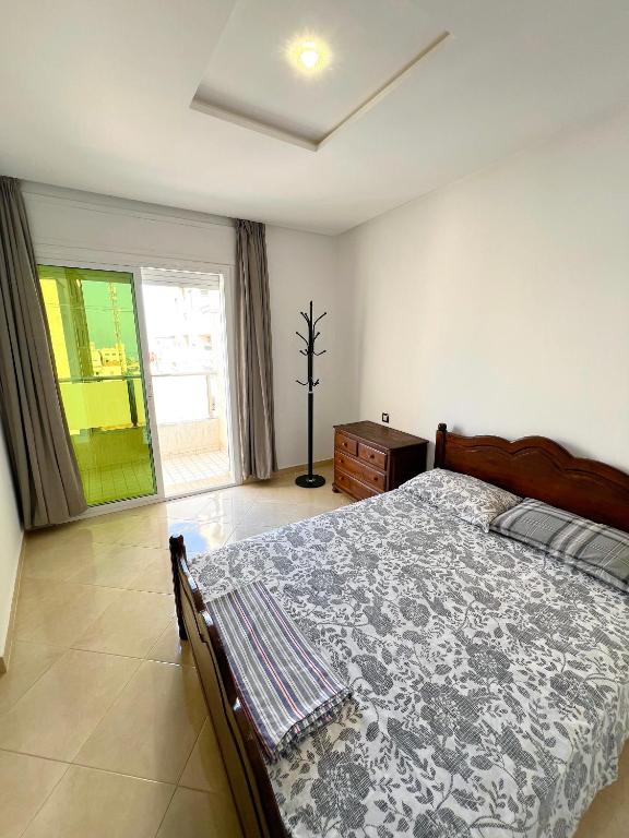 a bedroom with a bed and a dresser and a window at Visit Chamal - Palmera 4 in Oued Laou