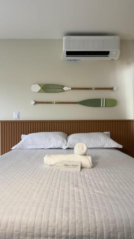 a white bed with a towel on top of it at Loft Duplex Moderno - 50m da Praia - Ar - Wi-Fi in Salinas da Margarida