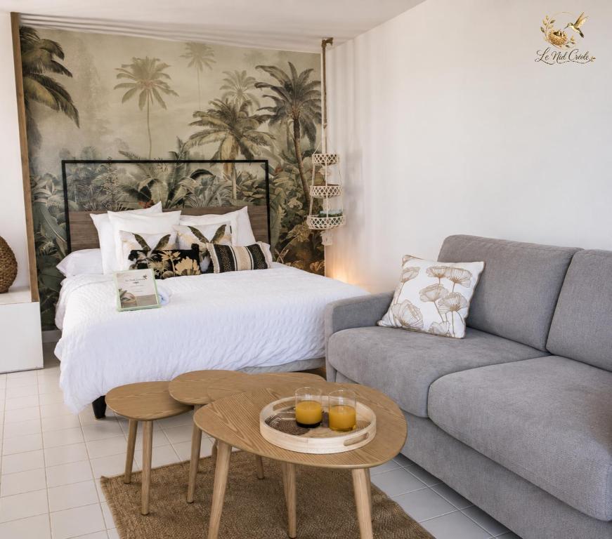 a living room with a bed and a couch at Le Nid Créole in Belle-Allée