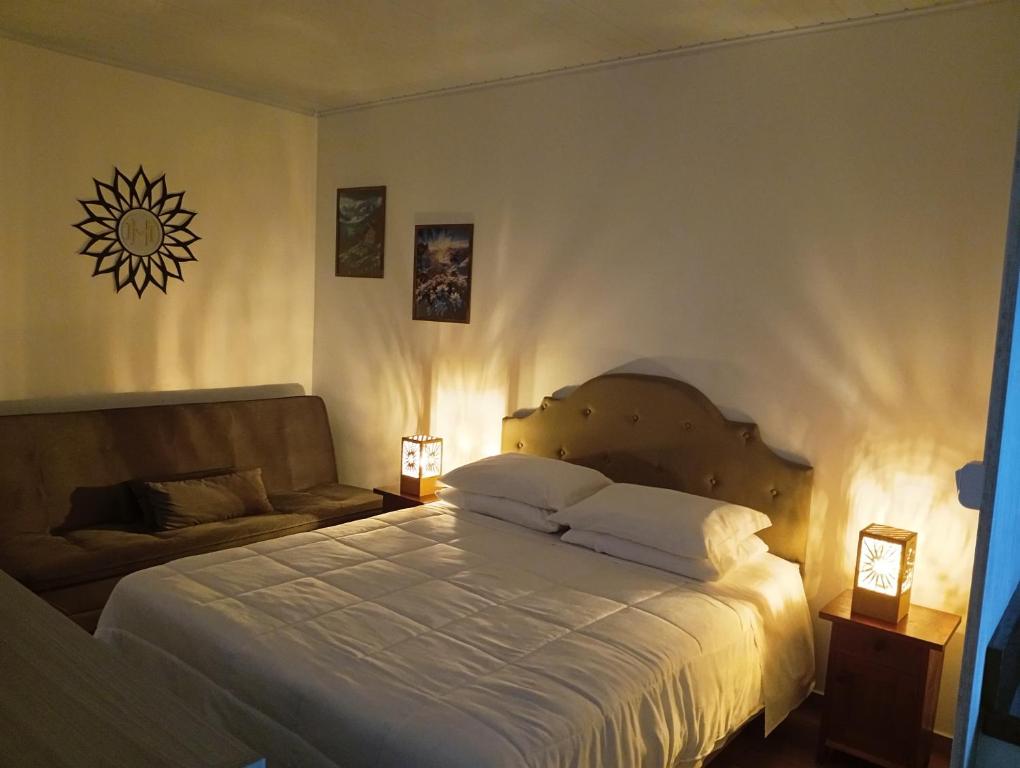 a bedroom with a large bed and a couch at Hospedaria Mitterer in Treze Tílias