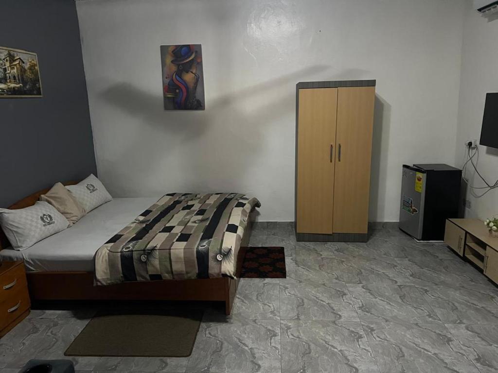una camera da letto con un letto e un armadio in legno di Hotel Caledonian a Chantan