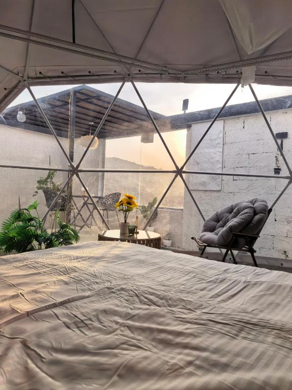 a room with a bed and a chair in a tent at سكوْن in Al Baha
