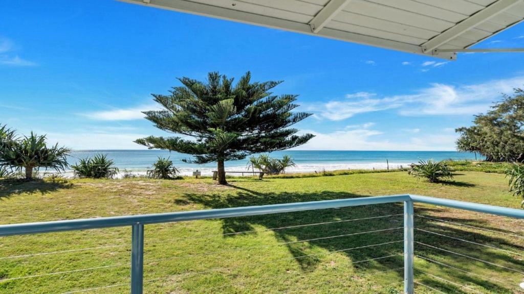 a view of the beach from the balcony of a house at Frangipani Cottage in Wooli