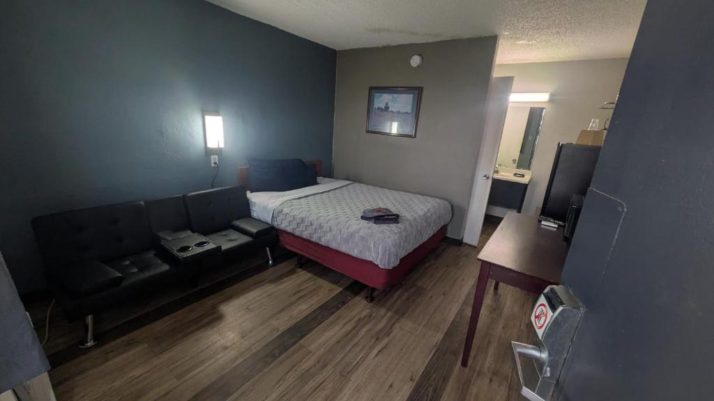 a small bedroom with a bed and a couch at Queen Bed Hotel Room 225 in Amarillo