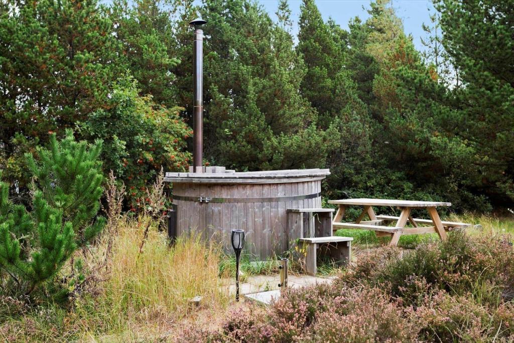 a wooden shed and a picnic table in a field at 0140-Romo-Kap-Farvel-7 in Høm