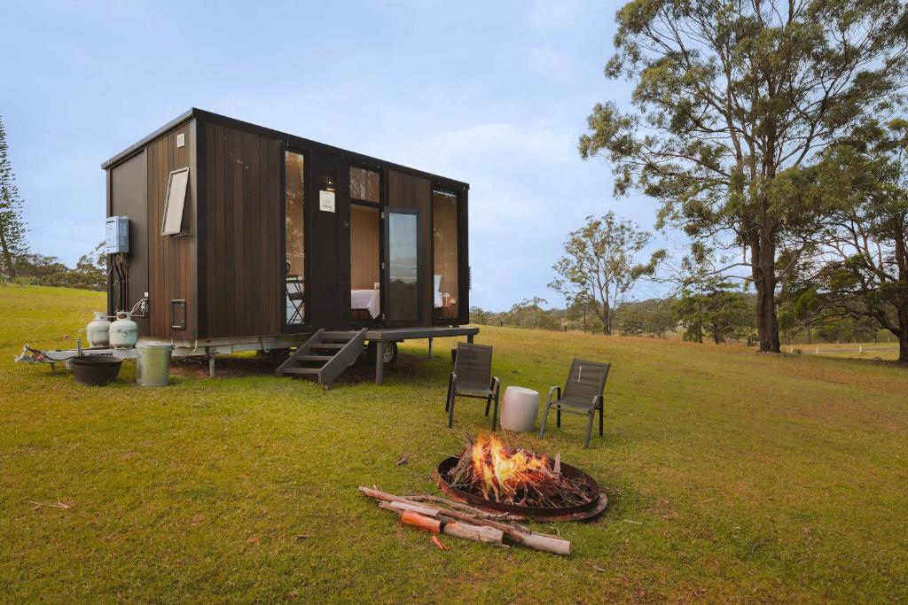 a tiny house with a fire in the yard at Two-Ki by Tiny Away in Rainbow Flat