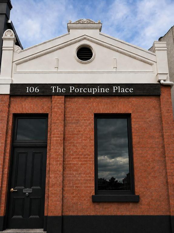 a brick building with a sign that reads the porcupine place at The Porcupine Place in Sale