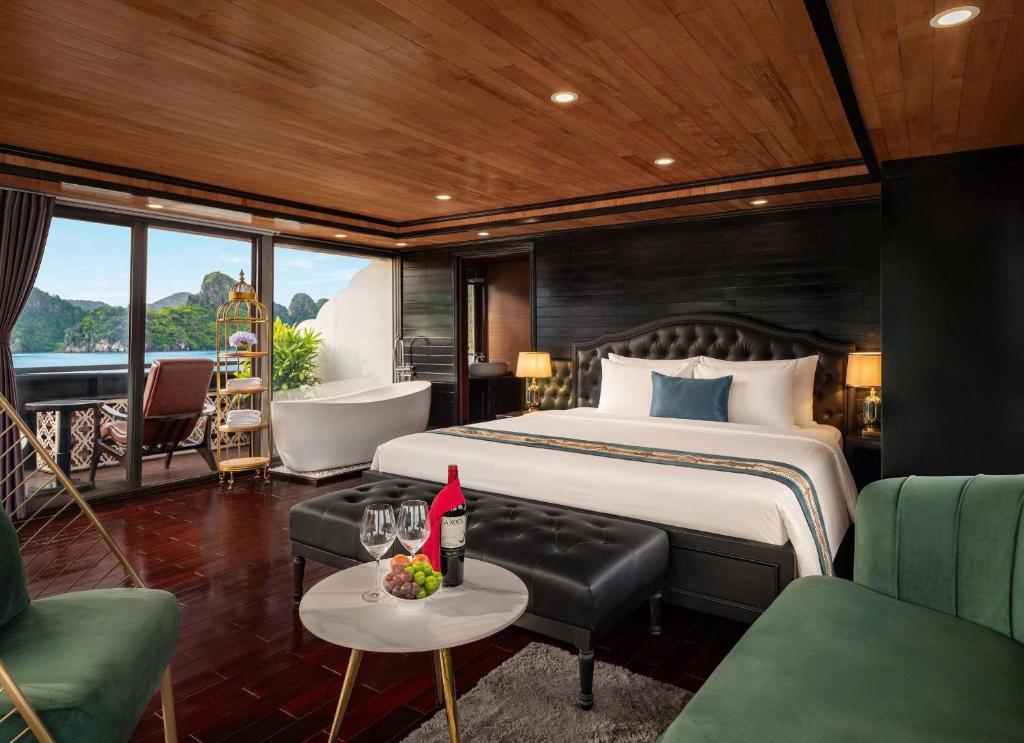 a bedroom with a bed and a living room at Aqua Elegance Cruise - Halong Bay by AHG in Ha Long