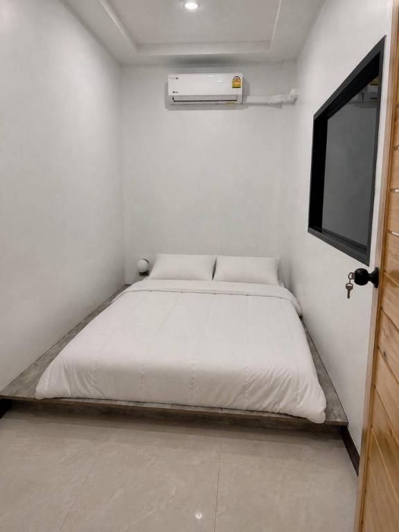 a white bedroom with a bed in a room at 9 mins to BTS Queen Bed Private Room - Share Bath in Amphoe Phra Khanong