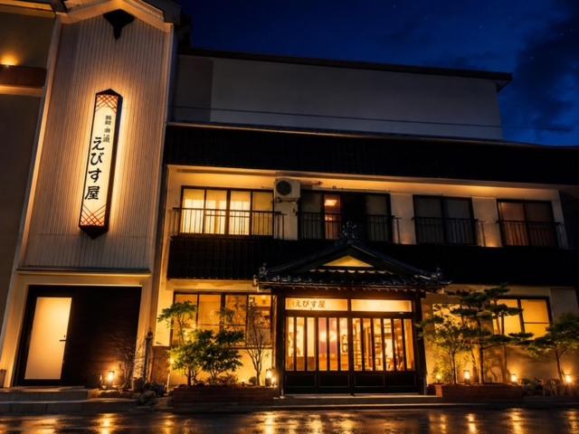 a building with a sign on it at night at 藤の湯えびす屋 in Yunokami