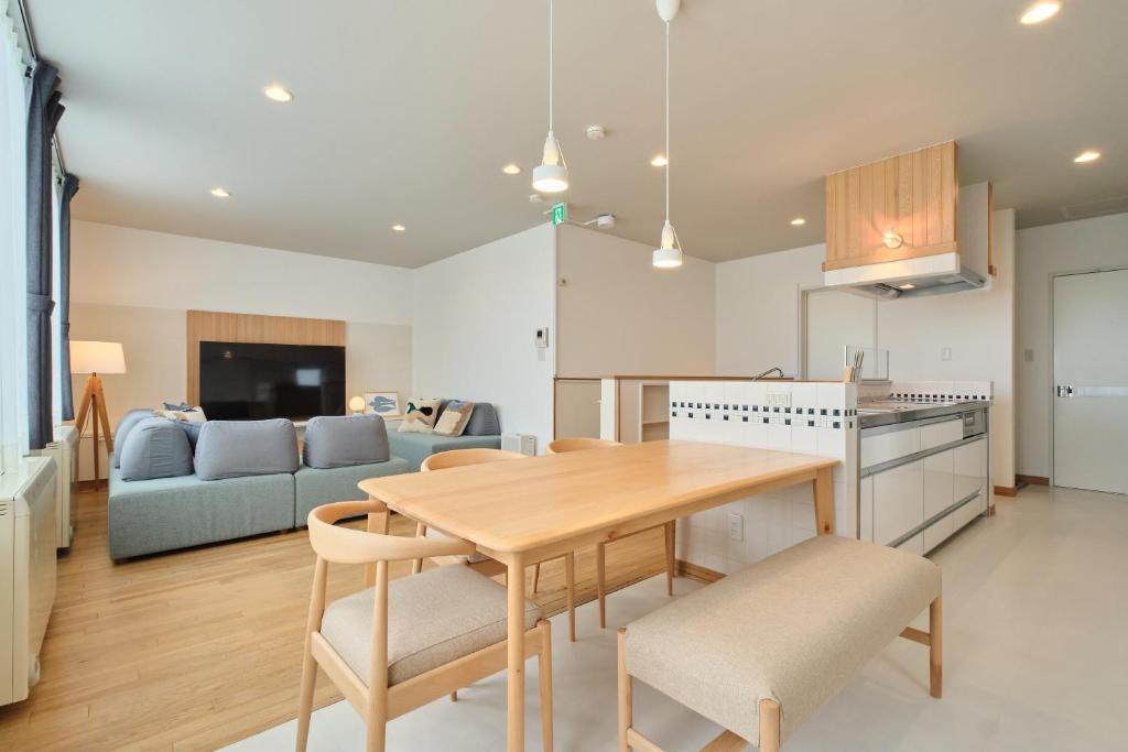 a kitchen and living room with a table and a couch at Suzuran Haus in Higashikawa
