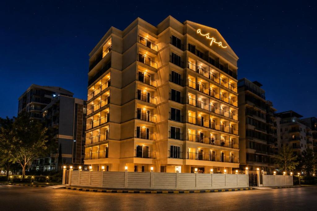 a large building with lights on it at night at ASPA Apartments in Navi Mumbai
