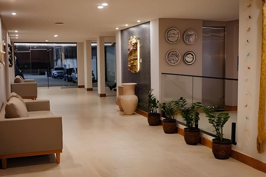 a hallway with potted plants and clocks on the wall at Hotel Amazon Seasons VN in Belém