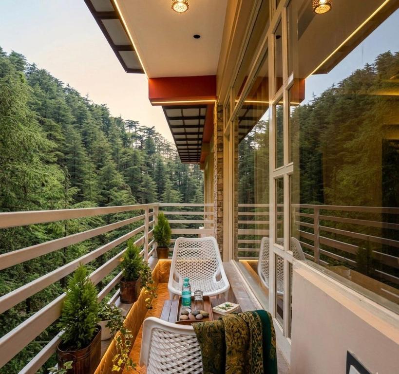 a balcony of a house with a table and chairs at Decent Stays Rooms and Apartments in Shimla