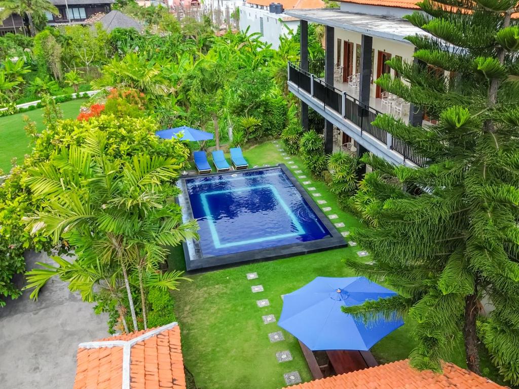 an aerial view of a resort with a pool and umbrellas at Pondok Lulik Homestay Canggu in Canggu