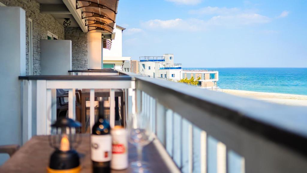 a balcony with a view of the beach and the ocean at Goseong Araenmaru Pension in Goseong