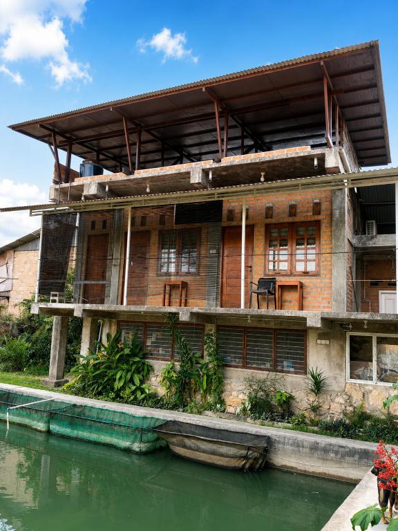 an old building next to a body of water at Kaliele House in Domine Eduard Osok Airport