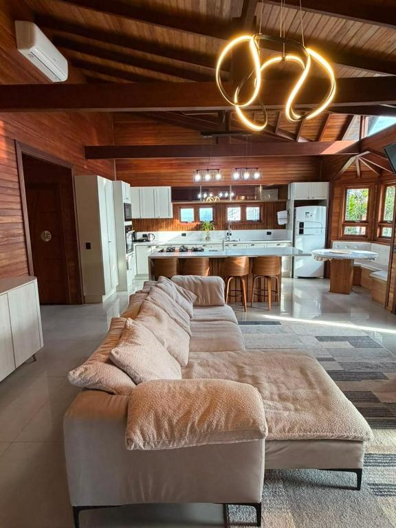a large living room with a couch and a kitchen at Chalé Rossa in Xangri-lá