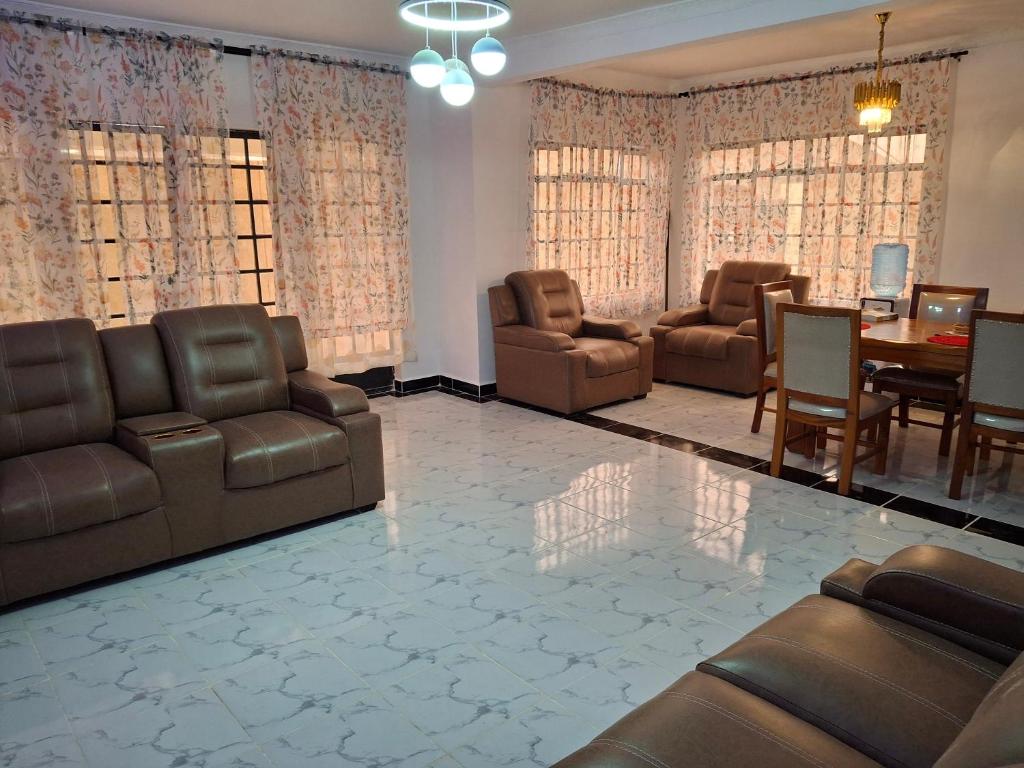 a living room with leather furniture and a dining room at BlessRoyal Home in Kitengela 