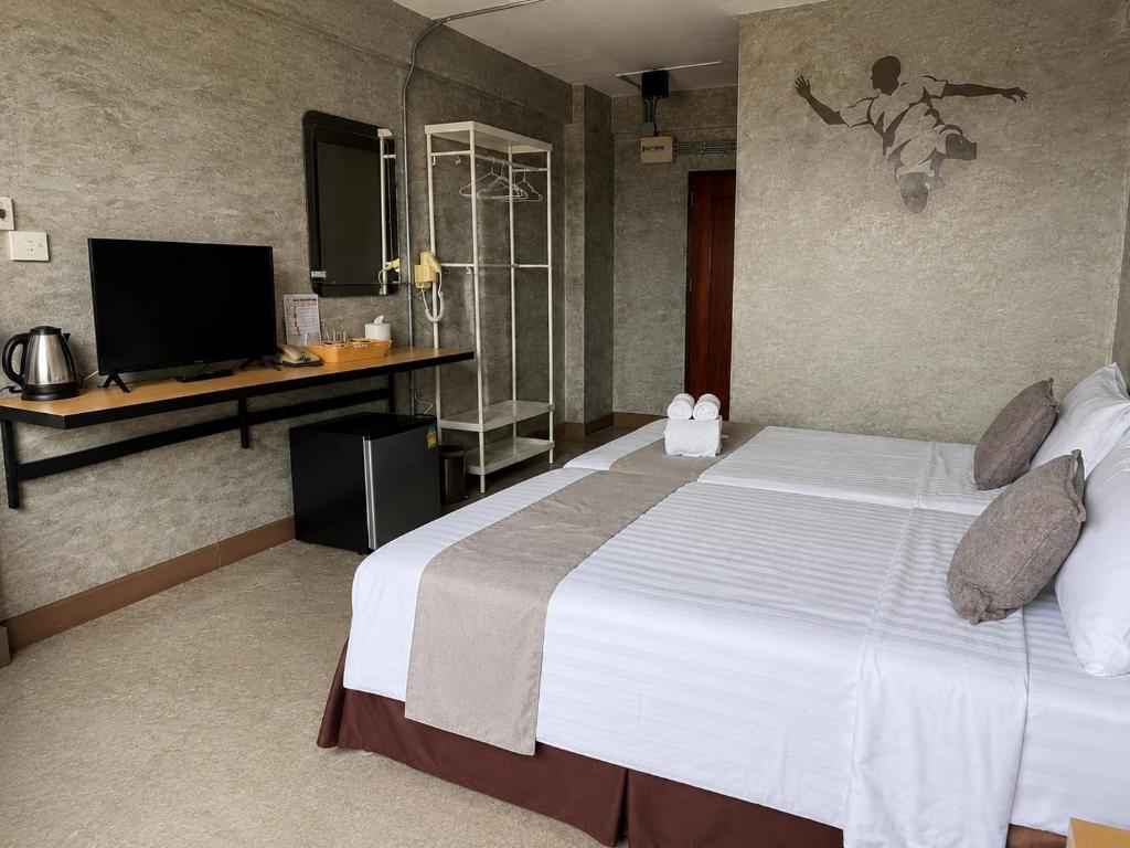 a hotel room with a large bed and a tv at Happyland Mansion in Bangkok