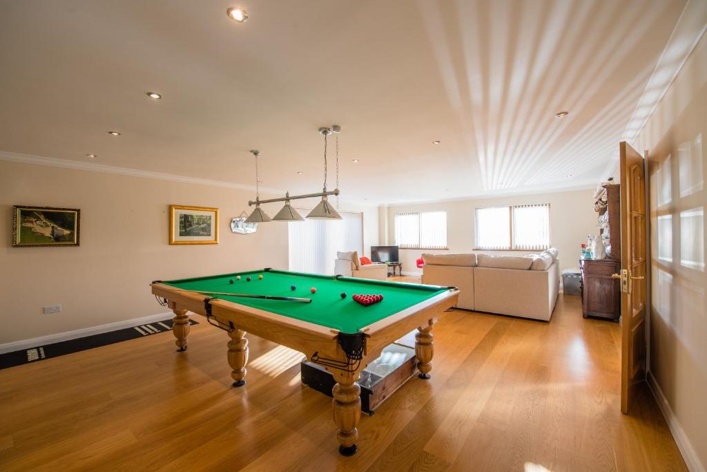 a living room with a pool table in it at Y Grange in Llanfihangel-y-creuddyn