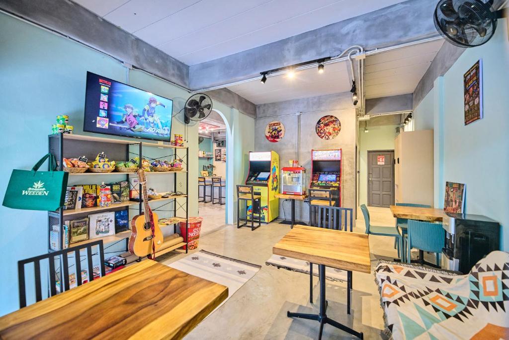 a room with a table and chairs and a tv at Noodle Shop Hostel in Nathon Bay