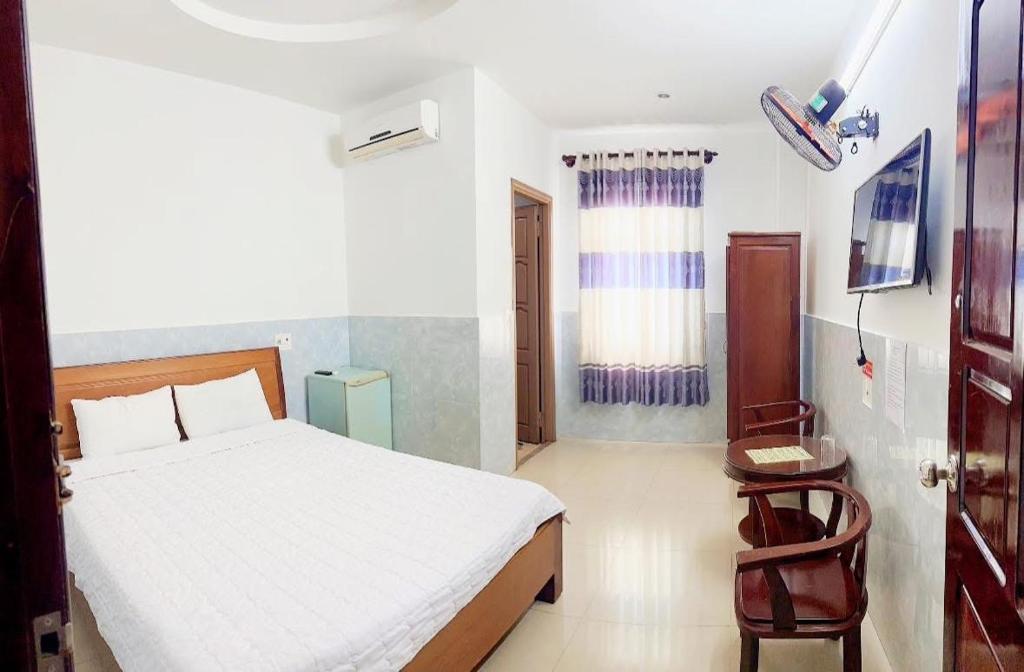 a bedroom with a bed and a chair in it at HOTEL HOA LU Buôn Ma Thuột in Buôn Kô Sir